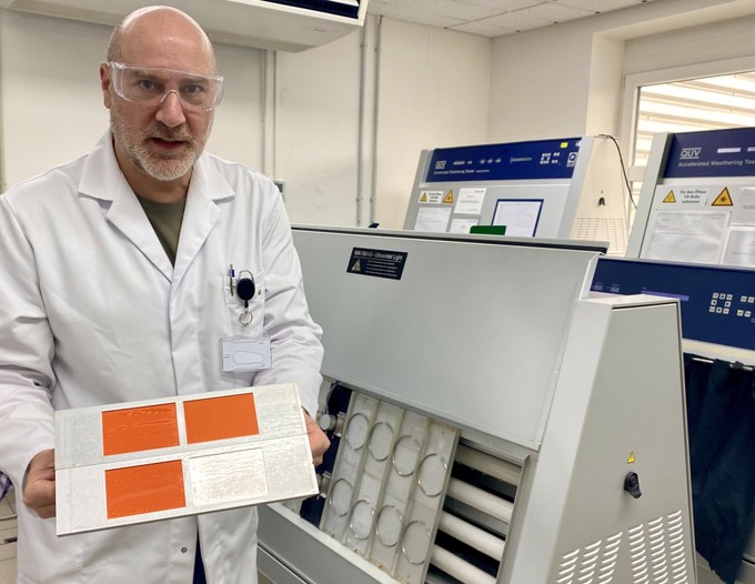 Heiko Bandholz zeigt im Prüfzentrum von Mankiewicz Lackproben, die aus einem Bewitterungsgerät kommen.