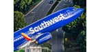 Boeing 737-800 von Kapitän Ted Orris beim Abschiedsflug: Die Aufnahme wurde aus einem Hubschrauber fotografiert, in die Kamera winkt Orris' Kopilot.