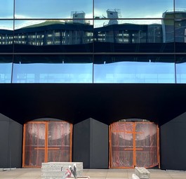 Parkhaus spiegelt sich in Fassade: Einer der Eingänge zur großen Halle ...