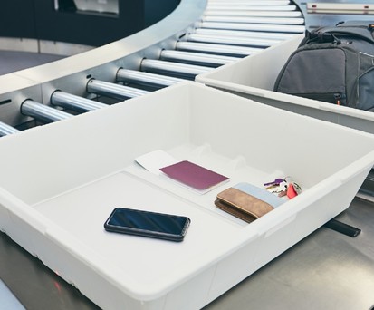 Smartphone in der Plastikwanne: In den USA derzeit nicht erwünscht.