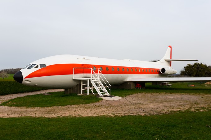 Der Flieger steht auf einem Feld.