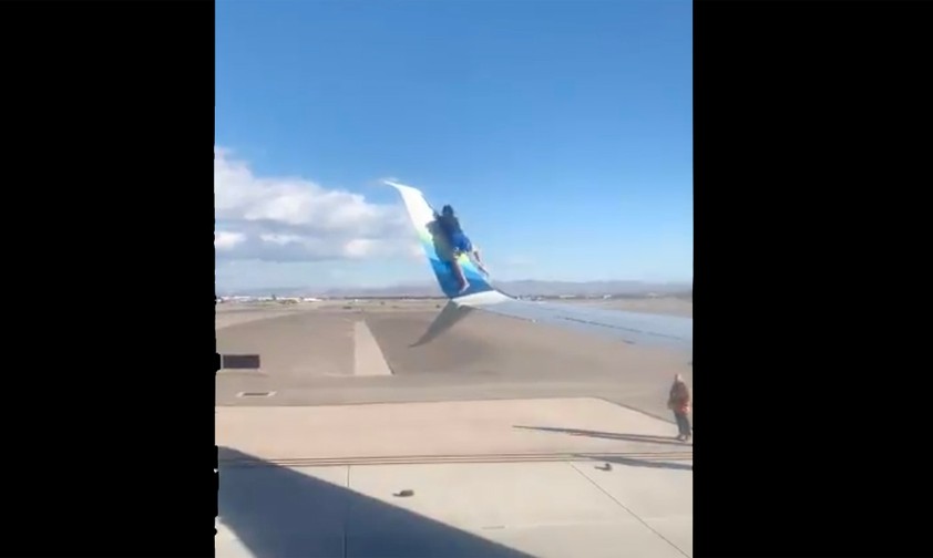 Mann steigt auf Flügel und will Winglet hochklettern