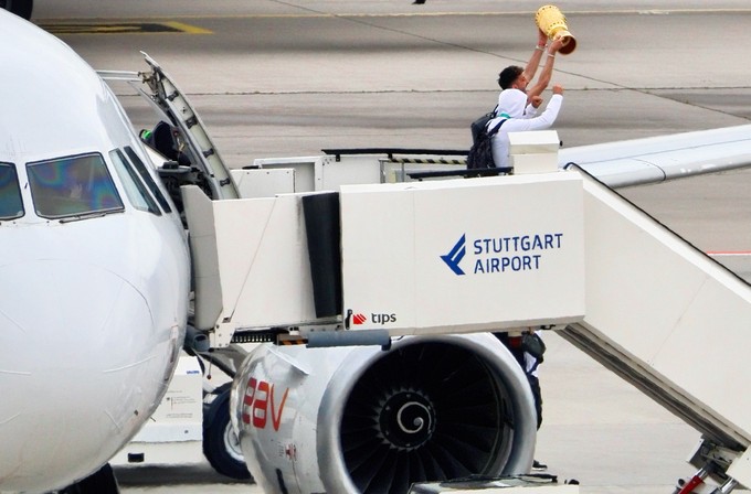 Die Spieler mit dem Pokal treten aus dem A320.