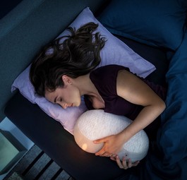 Roboter im Arm: Frau mit Somnox-Gadget.
