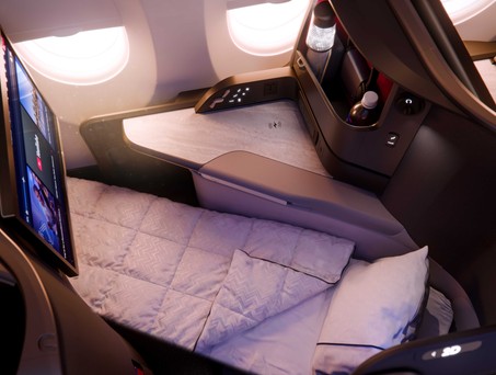 Ein Sitz der Delta One Suite im A350-1000 als Bettmodus mit Decke