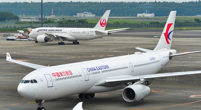 Airbus a330 von China Eastern im Hintergrund steht ein Flugzeug von Japan Airlines: Chinesische Airlines erleben derzeit eine Stornierungswelle für Japan-Flüge.